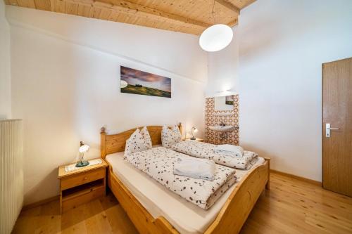 a bedroom with a wooden bed and a wooden floor at Eggerhof Familienparadies in Verano