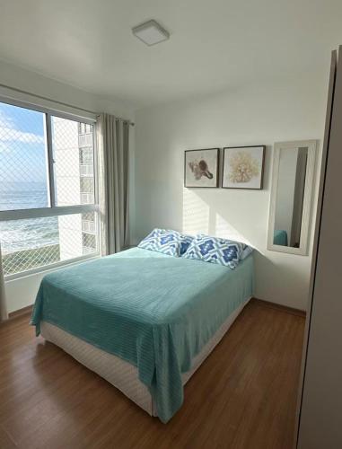 a bedroom with a bed and a large window at Resort com vista mar! in Barra Velha