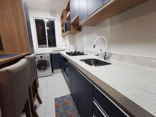a kitchen with a sink and a washing machine at Resort com vista mar! in Barra Velha