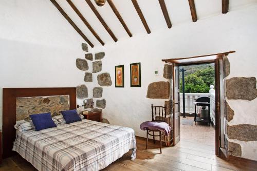 a bedroom with a bed with blue pillows on it at La casa nueva in Fátaga