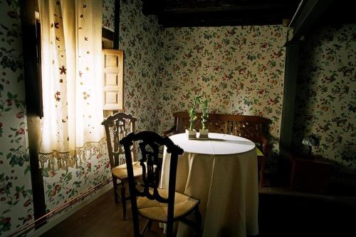 a table and chairs in a room with floral wallpaper at Reoyo 1 in Mambrilla de Castrejón