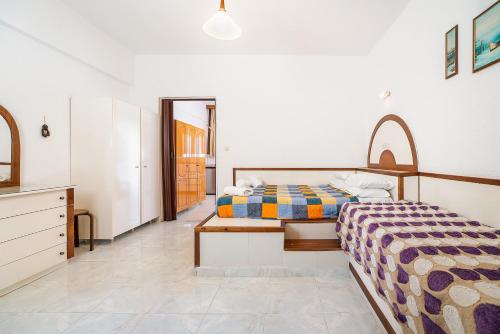 a bedroom with two beds and a dresser at Panorama Tilos Apt B in Tílos