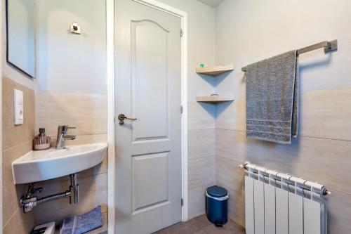 a bathroom with a sink and a white door at Habitacion Doble Jardin in Camarles