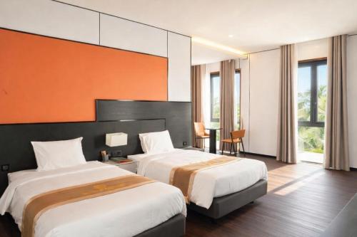 a hotel room with two beds and a table at H- Dragon Hotel in Ðố Sơn