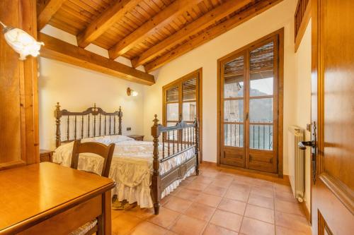 a bedroom with a bed and a wooden door at Casa Vilanova in Peramea