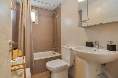 a white bathroom with a sink and a toilet at vv Sueño Del Mar in Costa de Antigua