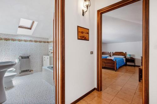 a bathroom with a mirror and a bedroom with a bed at Appartamento Rupestre 2.0 in Manerba del Garda