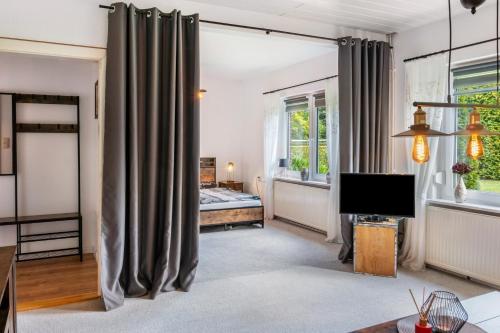 a living room with gray curtains and a television at Ferienhaus Behrends in Emden