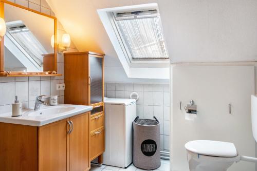a bathroom with a sink and a toilet with a skylight at Ferienhaus Behrends in Emden