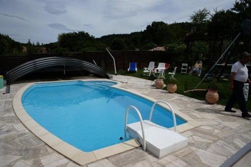 a person walking by a large swimming pool at Gîte Clarisse, piscine, animaux, pk in Allemagne-en-Provence