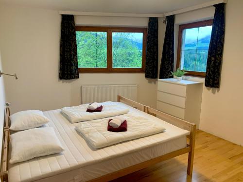 two beds in a room with two windows at Haus Auner Top 1 in Westendorf