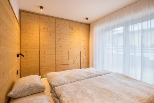 a bedroom with two beds and a window at Apartments Armeri Black Dolomites in San Vigilio Di Marebbe