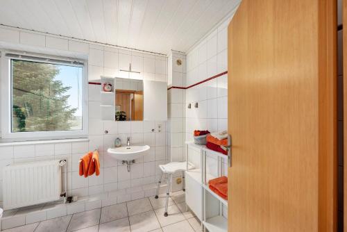 a white bathroom with a sink and a window at Huus Meernmank in Achtrup