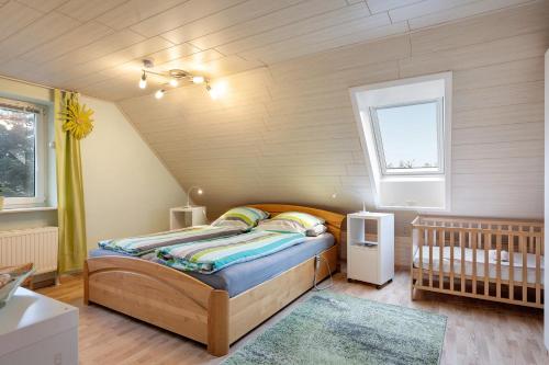 a bedroom with a bed and a crib in a room at Huus Meernmank in Achtrup