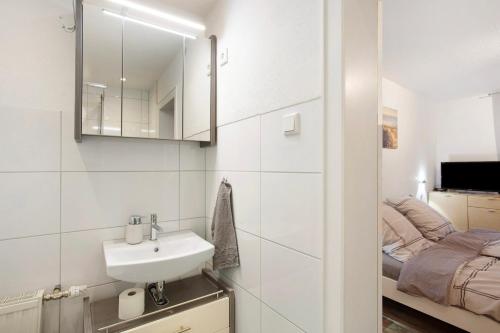 a white bathroom with a sink and a bed at Lausebuche Im Sauerland in Lennestadt