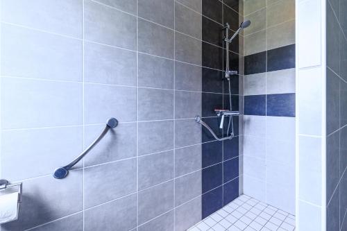a bathroom with a shower with blue and gray tiles at Maison La Dune, Piscine et Jardin in Messanges
