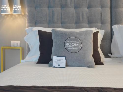 a bed with a pillow with a sign on it at Anjoy&Bleev Rooms in Rho