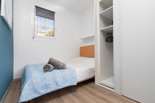 a small bedroom with a bed and a mirror at Bella mar in L'Escala