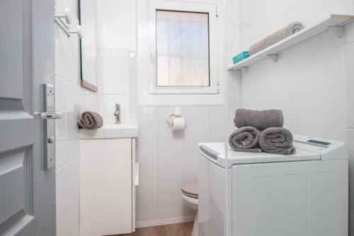 a white bathroom with a toilet and a sink at Bella mar in L'Escala