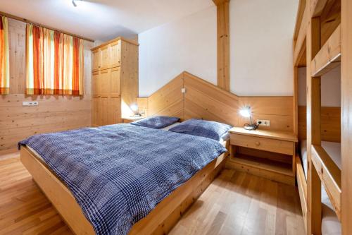 a bedroom with a large bed with blue sheets at Lindenhof Apt 8 in Vandoies