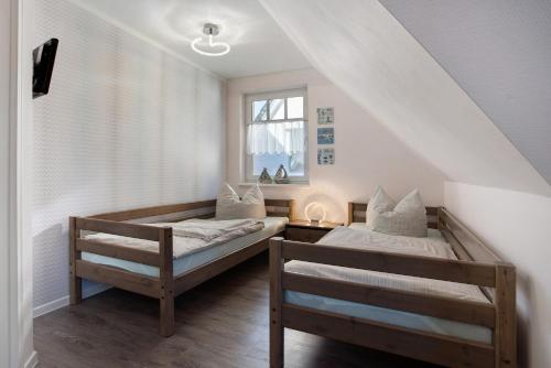 a bedroom with two beds and a window at Haus Segelboot Hirtenweg 3c in Zingst