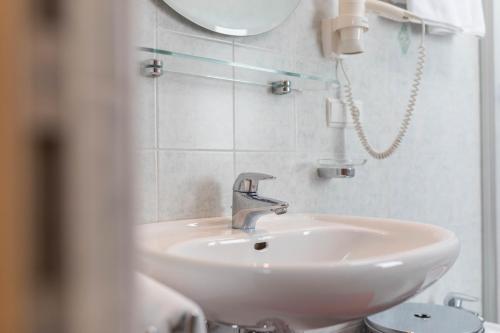 a white sink in a bathroom with a mirror at Apartment Kornblume - Mesnerhof in Sand in Taufers