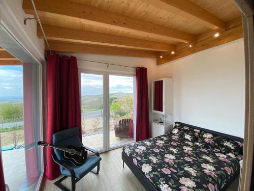 a bedroom with a bed and a chair and a window at Casa Vacanze Elios in Valdamonte