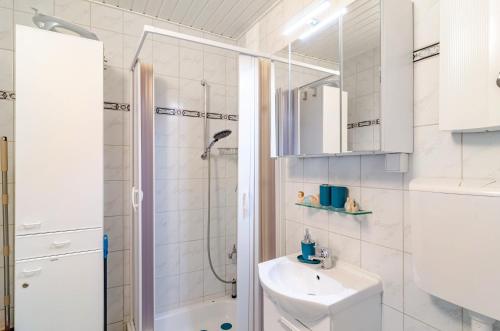 a white bathroom with a shower and a sink at Perle von Berumbur in Berumbur