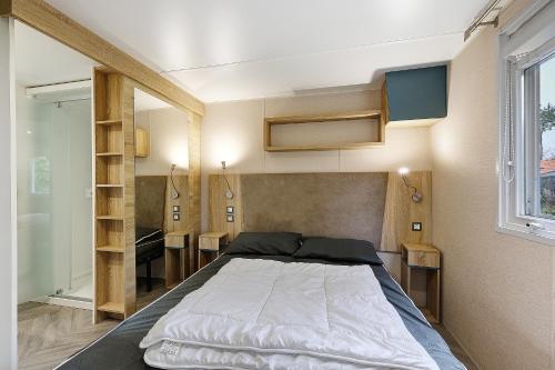 a bedroom with a large bed in a room at Mobile Home du Bois Dormant in Saint-Jean-de-Monts