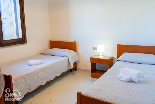 a room with two beds with towels on them at Villa Malamuri in Budoni