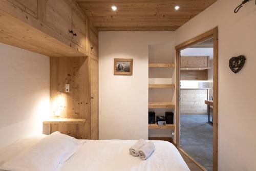 a bedroom with a bed and a mirror at Appartement au centre de megève in Megève