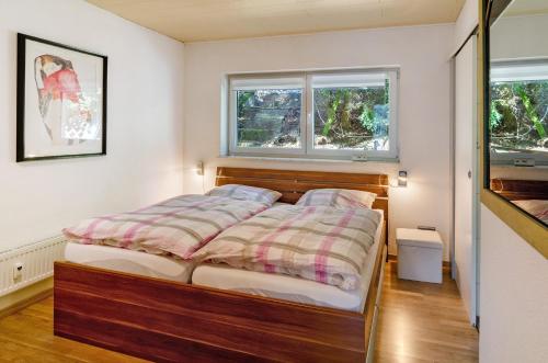 a bedroom with a bed and two windows at Ferienwohnung Kupfer in Niestetal