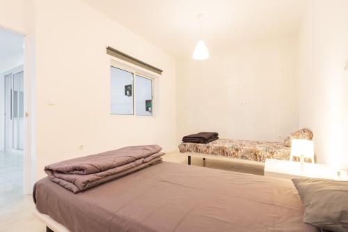 a bedroom with two beds and a window at Casa Io in Mindelo