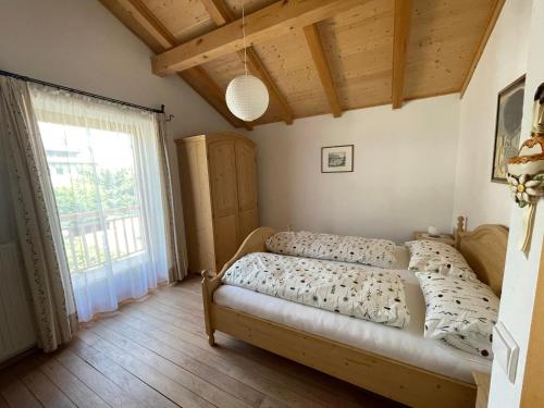 a bedroom with two beds and a large window at Mendelhaus in Mendola