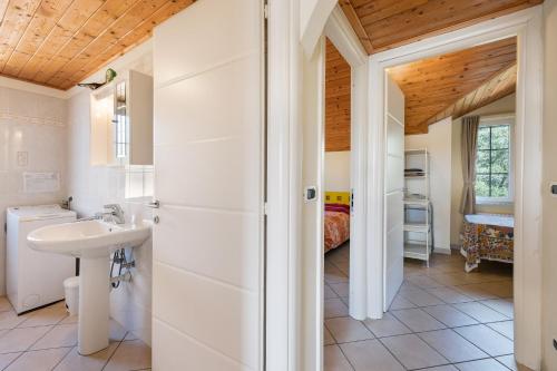 a bathroom with a sink and a toilet and a bedroom at La Casa di Lady in Ceriale