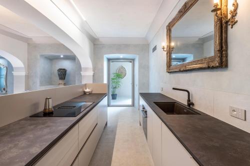 a kitchen with a sink and a mirror on the wall at Abaye I Champagne Charm Adults Only in Soiano del Lago