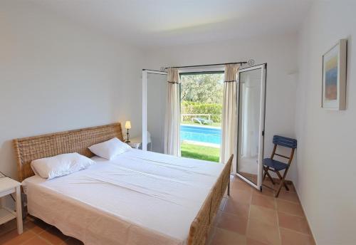 ein Schlafzimmer mit einem Bett und einer Tür zu einem Pool in der Unterkunft Flor Begur in Begur