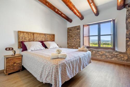 a bedroom with a large bed and a large window at La Casa Gran Clariana in Gornal