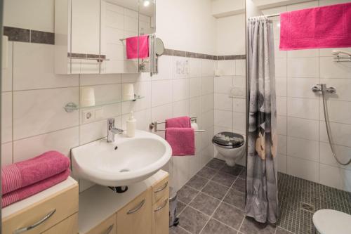a bathroom with a sink and a shower with pink towels at Haus Ruther - Wohnung 1 in Bad Saulgau
