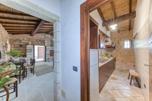 an open kitchen and dining room in a stone house at Tenuta Pizzola in Nociglia