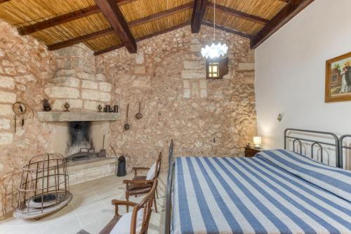a bedroom with a bed and a stone wall at Tenuta Pizzola in Nociglia