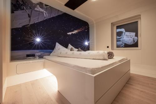 a bedroom with a white bed with a large window at Sonnleiten Sonne Mond u Sterne in Collepietra
