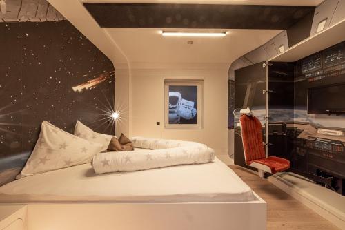 a bedroom with a bed and a tv and a chair at Sonnleiten Sonne Mond u Sterne in Collepietra