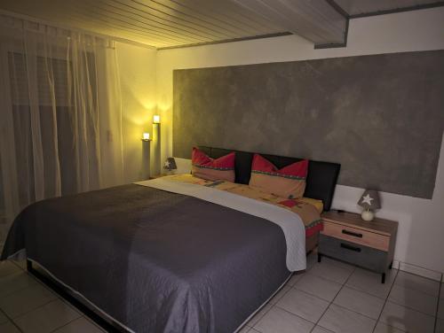 a bedroom with a large bed with red pillows at Ferienwohnung Sonnenblick in Eisenbach