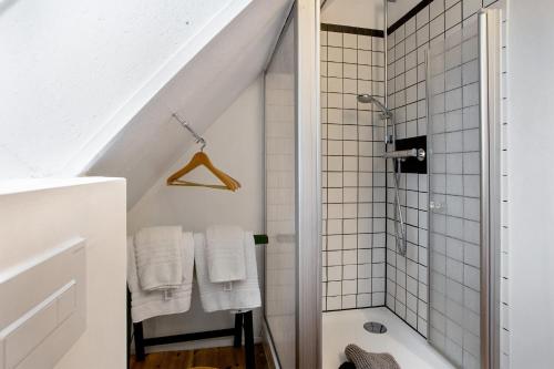 ein Badezimmer mit Dusche und weißen Fliesen in der Unterkunft McIntosh in Groß Wokern