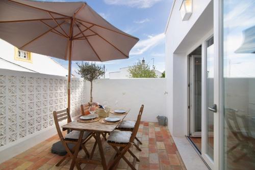 a wooden table with an umbrella on a patio at Casa de Benafim 1 in Benafim