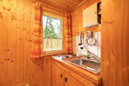 a kitchen with a sink and a window at Bungalow 34 - Kimbucht in Reichendorf