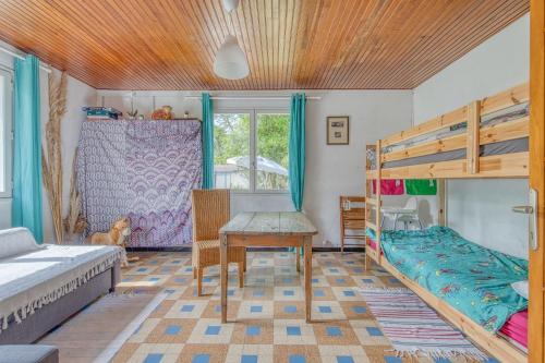a bedroom with two bunk beds and a table at Petite maison rustique et atypique in Hourtin