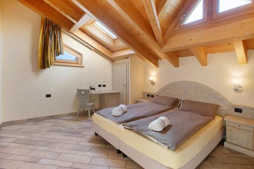 a bedroom with a large bed with a wooden ceiling at Appartamento 8 in Livigno