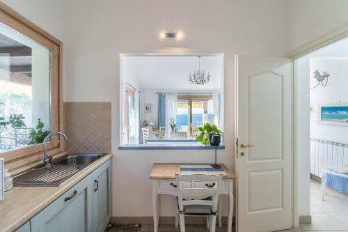 a kitchen with a sink and a table and a window at Villa Daisy in Quartu SantʼElena